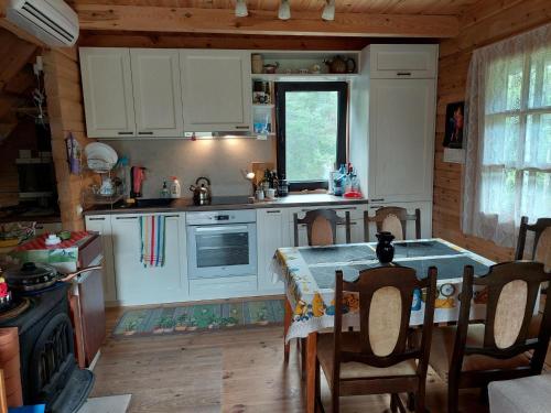 a kitchen with a table and a kitchen with white cabinets at Juniper holiday house in Kassari with sauna in Hiiumaa