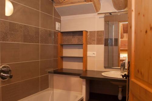 a bathroom with a sink and a tub and a mirror at L'Aiglon - spacious 2-bedroom apartment with log fire in Sainte-Foy-Tarentaise