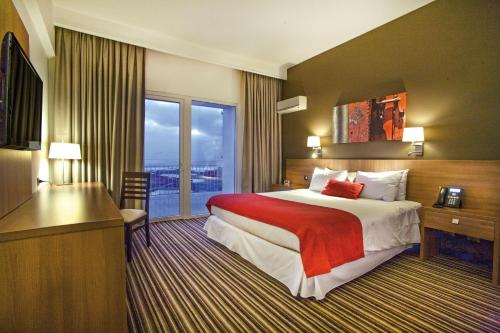アントファガスタにあるHotel Antofagastaのベッドと大きな窓が備わるホテルルームです。