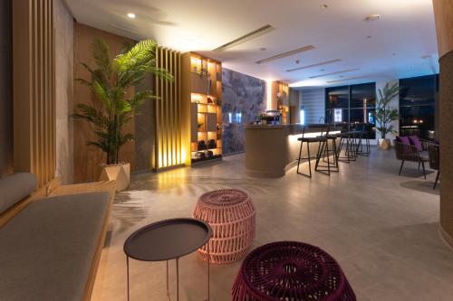 a lobby with tables and chairs and a bar at Kuwait Grand Hotel in Kuwait
