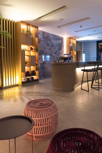 a lobby with tables and chairs and a counter at Kuwait Grand Hotel in Kuwait