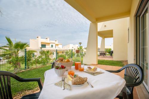 une table avec une assiette de nourriture sur un balcon dans l'établissement Glenridge Resort By Albufeira Rental, à Albufeira