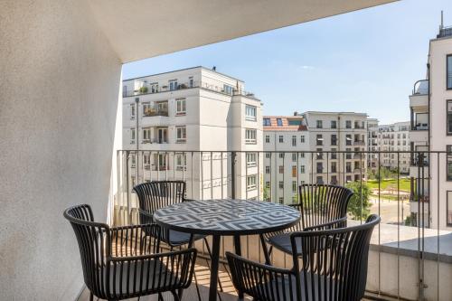 een balkon met een tafel en stoelen en een raam bij numa I Boxer Rooms and Apartments in Berlijn