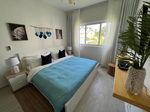 1 dormitorio con 1 cama grande con manta azul en Casa Mulata Paseo del Mar Pool & Playa en Punta Cana