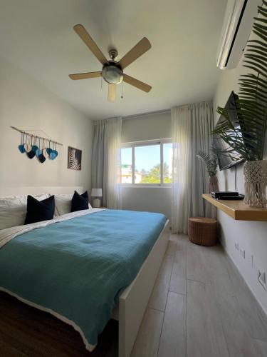 een slaapkamer met een groot bed met een plafondventilator bij Casa Mulata Paseo del Mar Pool & Playa in Punta Cana