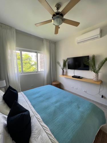 een slaapkamer met een groot bed met een plafondventilator bij Casa Mulata Paseo del Mar Pool & Playa in Punta Cana