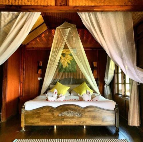 a bedroom with a canopy bed with stuffed animals on it at Tree House Bungalows Koh Tao in Koh Tao