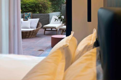 a view of a bed and a patio with a chair at Boutique Hotel Sirmione in Sirmione
