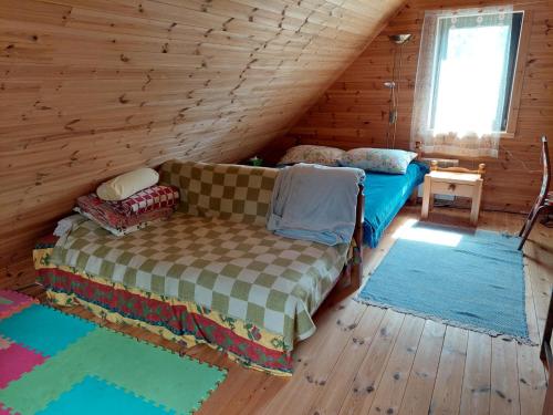 a living room with a couch in a log cabin at Juniper holiday house in Kassari with sauna in Hiiumaa