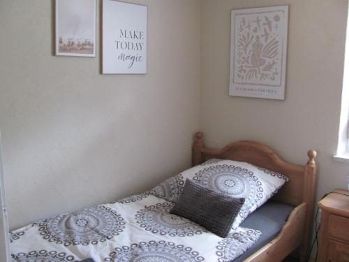 una camera da letto con un letto con un cuscino e dei quadri di #2 Ruhiges gemütliches Gästezimmer mit 2 Einzelbetten Gemeinschaftsbad W-Lan Airport nah Late Night Check in Haus Nr 9,5 a Trunkelsberg