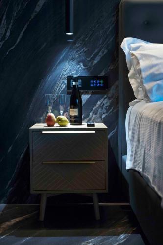 a night stand with a bottle of wine and glasses on it at Boutique Hotel Sirmione in Sirmione