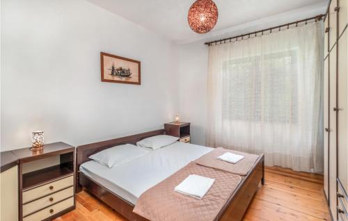 ein Schlafzimmer mit einem großen Bett und einem Fenster in der Unterkunft Lovely Apartment In Lopar With House A Panoramic View in Lopar