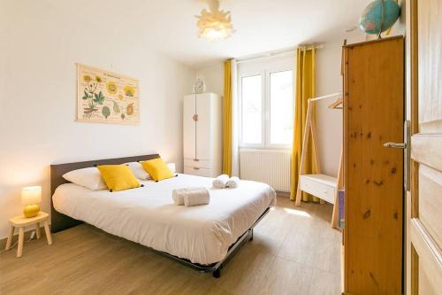sypialnia z dużym łóżkiem z żółtymi poduszkami w obiekcie Le Chateaubriand w mieście Dijon
