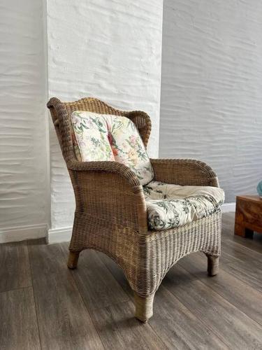 a wicker chair with a pillow in a room at Domizil in Schleiden