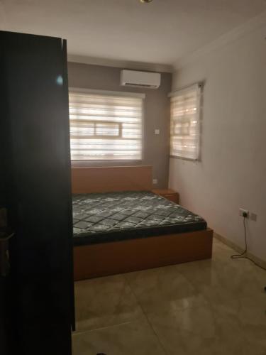 a bedroom with a bed and a window with blinds at koka in Ibadan