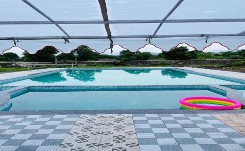 a swimming pool with two frisbees next to it at Vasant Vihar Resort in Kevadia