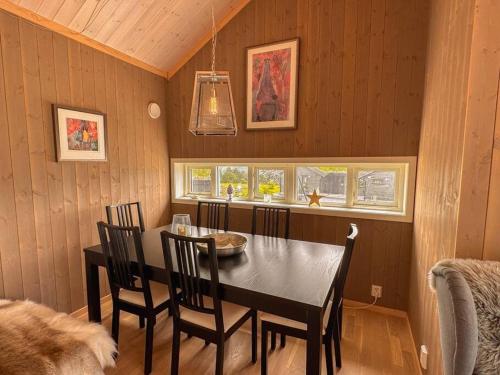 a dining room with a black table and chairs at Harevadet 211 in Hornindal