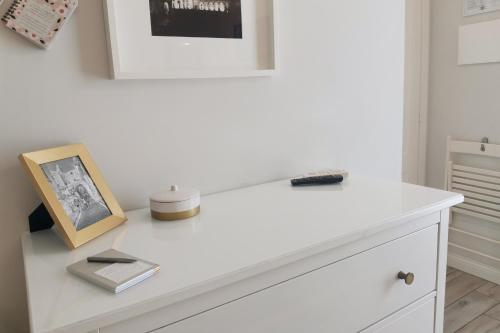 a white desk with a picture and a book on it at Vicolo Fiore Affittacamere in Matera