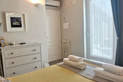 a bedroom with a bed and a dresser and a window at Vicolo Fiore Affittacamere in Matera