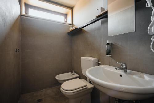 Un baño con un inodoro blanco y un lavabo. en 'RE-Dama Hostel, en Florencia