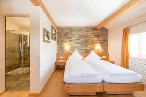 a bedroom with two beds and a shower at Berghotel Trübsee - Accessible Only by Cable Car in Engelberg
