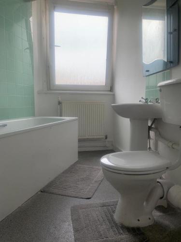 een badkamer met een toilet, een wastafel en een bad bij 1 Bed Apartment, Close to station in Londen