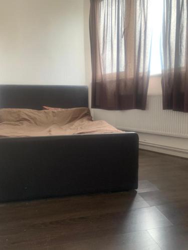 a bed sitting in a room with curtains at 1 Bed Apartment, Close to station in London