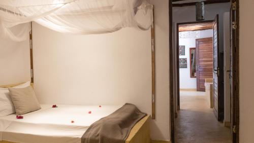 Un dormitorio con una cama y una puerta abierta. en Raha Lodge Zanzibar Boutique Hotel, en Jambiani