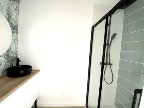 y baño con ducha y puerta de cristal. en Loft moderne avec terrasse en hyper centre-ville en Saint-Jean-de-Monts