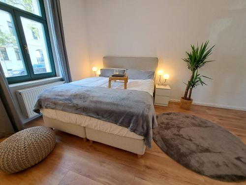 een slaapkamer met een bed en een groot raam bij Gemütliche helle Ferienwohnung in Dresden