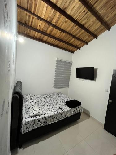 a bedroom with a bed and a flat screen tv at Apartamento de descaso por san Gil in San Gil