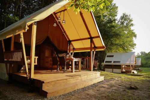 a gazebo with a table on a wooden deck at Глемпінг Шатро in Ulʼyaniki