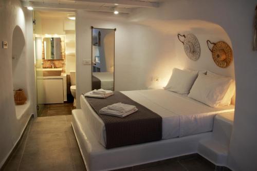 a white bedroom with a bed and a bathroom at il Marinero mandrakia in Mandrakia