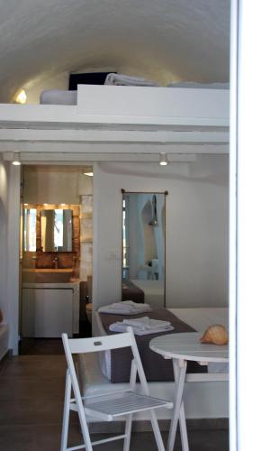 a loft bed with a table and chairs in a room at il Marinero mandrakia in Mandrakia