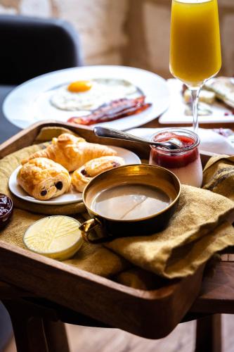 ein Tisch mit einem Tablett mit Essen und einem Glas Orangensaft in der Unterkunft Château de Belet in Saint-Aquilin
