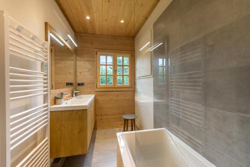 y baño con bañera y lavamanos. en ST JORIOZ-Chalet renove des Grands Champs proche lac et piste cycable- LLA Selections by Location lac Annecy, en Saint-Jorioz