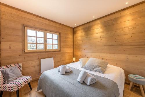 - une chambre avec des murs en bois, un lit et une fenêtre dans l'établissement ST JORIOZ-Chalet renove des Grands Champs proche lac et piste cycable- LLA Selections by Location lac Annecy, à Saint-Jorioz