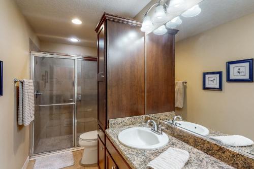 a bathroom with a shower and a sink and a toilet at The Cove House in Wildwood