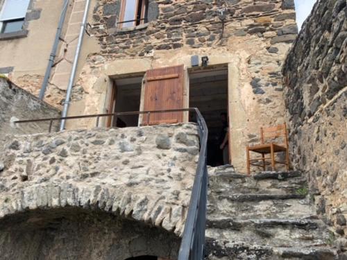 a stone building with a wooden door and stairs at maison de vigneron in Mareugheol