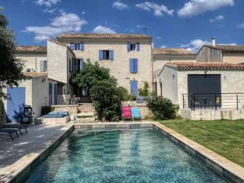 a house with a swimming pool in front of a building at Coeur de Provences in Saint-Didier
