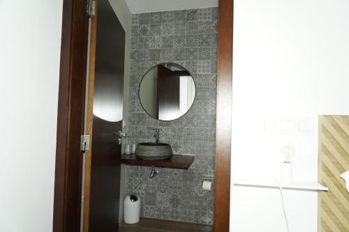 ein Badezimmer mit einem Spiegel und einem Waschbecken in der Unterkunft Casa Sabugueiro 