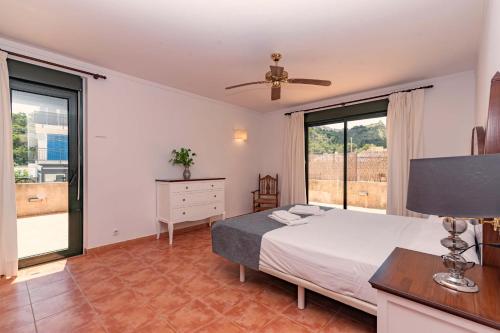 a bedroom with a bed and a large window at Villa Nogues in Cala de Sant Vicenc