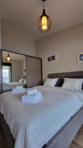 duże białe łóżko z ręcznikami w pokoju w obiekcie Novi Hills w mieście Herceg Novi