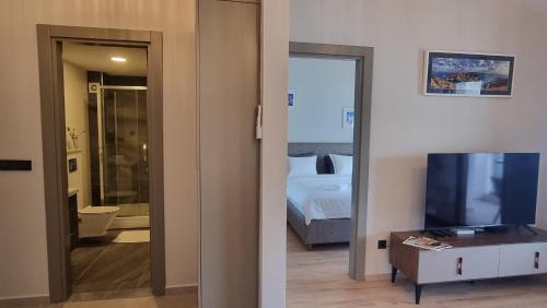 1 dormitorio con 1 cama y TV en una habitación en Novi Hills, en Herceg-Novi