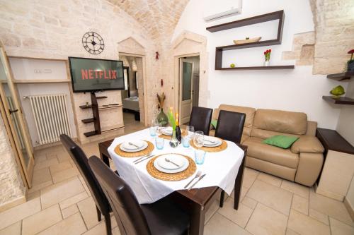 een eetkamer met een tafel en een bank bij Terrazza Mazzini - Suite Porta Piccènne in Cisternino