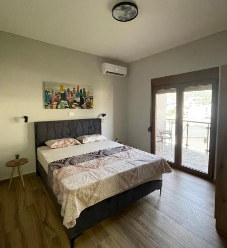 a bedroom with a bed with a clock on the wall at Apart Hotel XXL Lux in Dobra Voda