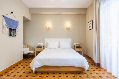 アテネにあるKolonaki Suites by Olala Homesのベッドルーム(白いシーツを使用した大型ベッド1台付)