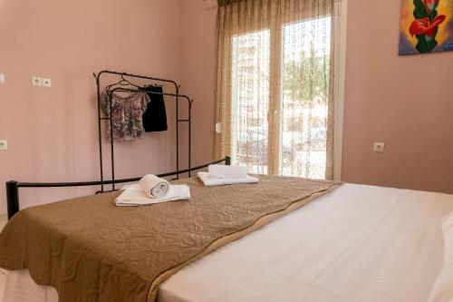 a bed with towels on it with a window at Aktia Apartments, Preveza in Preveza