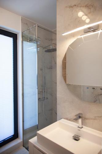 a white bathroom with a sink and a shower at Villa Dara and Todd in Sivota