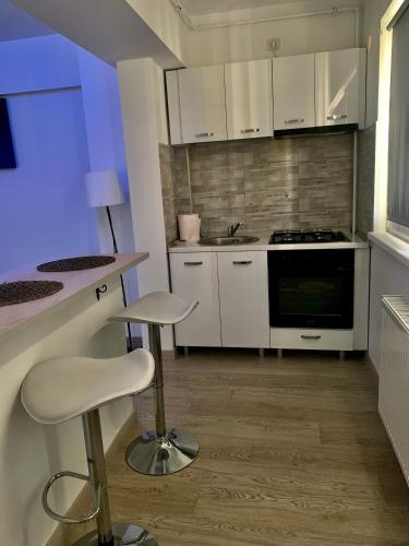 a kitchen with white cabinets and a stove top oven at Black&White Suites in Craiova